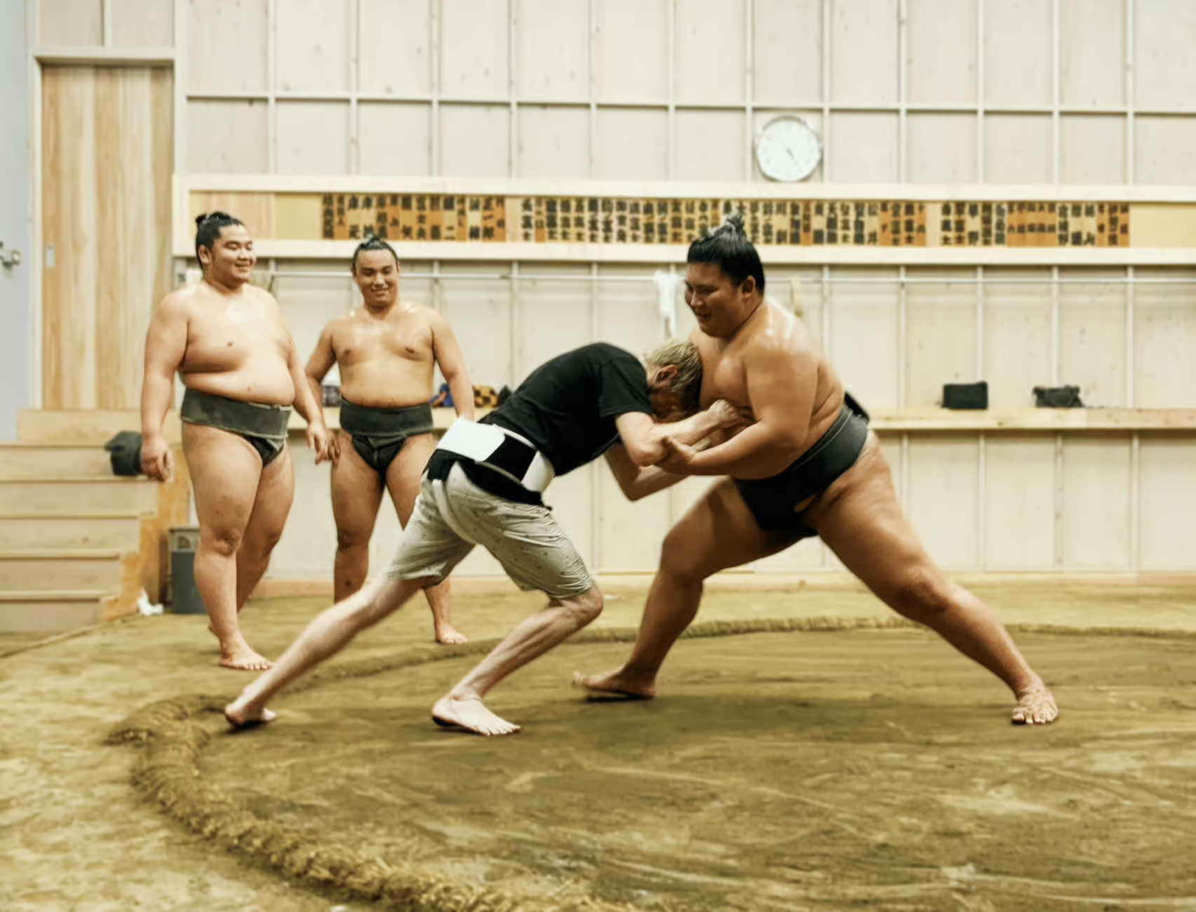 Guest attempting a tachiai challenge with a sumo wrestler at Kokugikan Tokyo